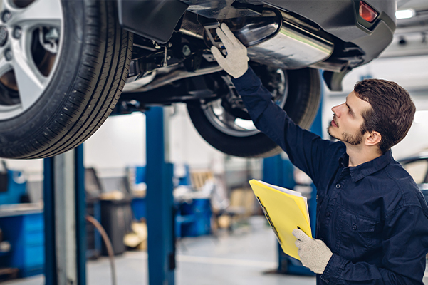 Auto car repair service center. Mechanic examining car