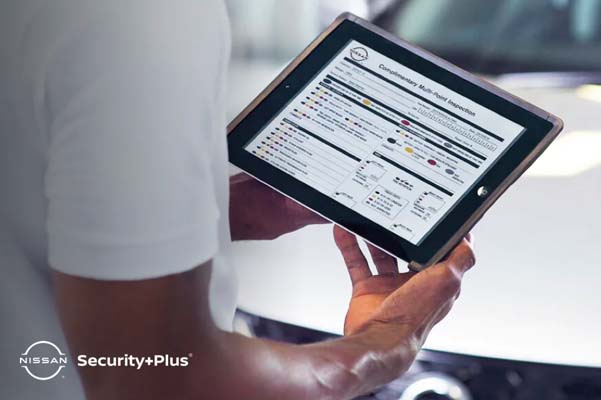 customer holding an ipad looking at nissan security+plus information