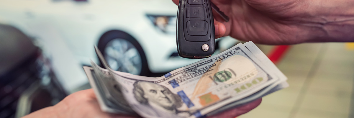 car salesman handing car keys to customer