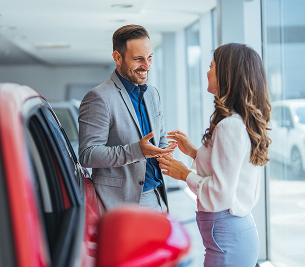 Dealership employee smiling speaking to a customer