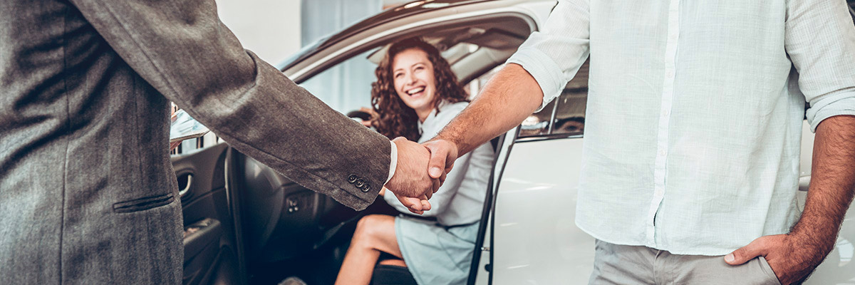 Dealer shaking hands with new car shopper